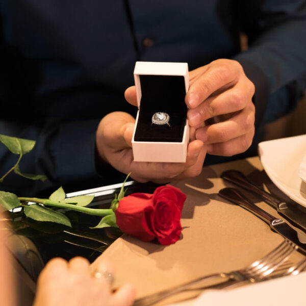 Sängerin für den Heiratsantrag. Auf dem Bild ist ein Ring in einer Schatulle zu sehen. Man sieht nur die Hände mit dem Ring, aber es wird deutlich, dass ein Mann einen Heiratsantrag macht.