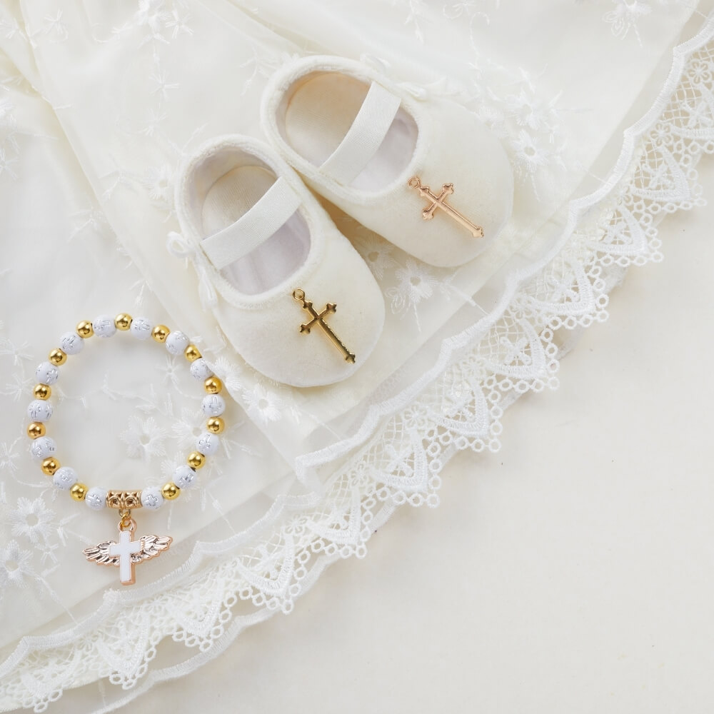 Sängerin für die Taufe in der Kirche. Auf dem Bild sehen wir weisse Baby Schuheund Kleidung für die Taufe eines Kindes.